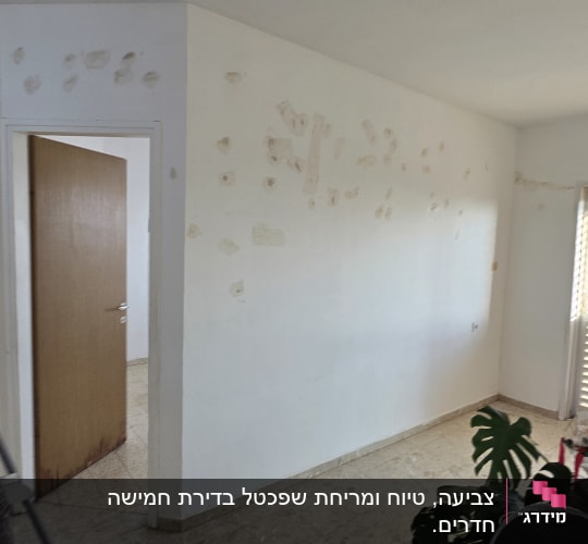 קיר עם תיקוני צבע בחדר ריק